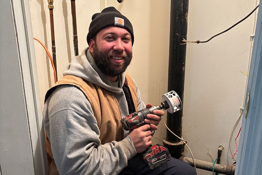 HVAC technician drilling pipe