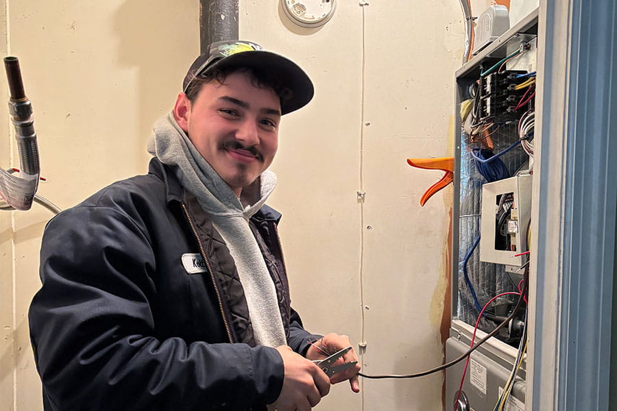 HVAC technician servicing furnace panel